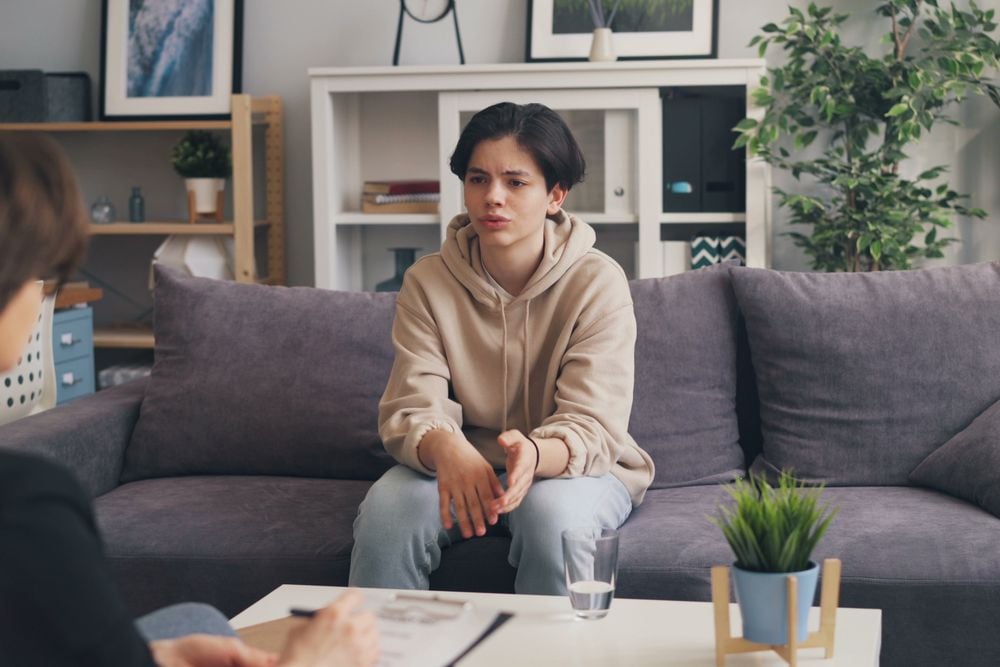 Teen talking privately with a therapist during a counseling session