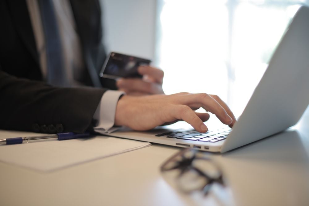 Person comparing therapist profiles and credentials on a laptop at a kitchen table